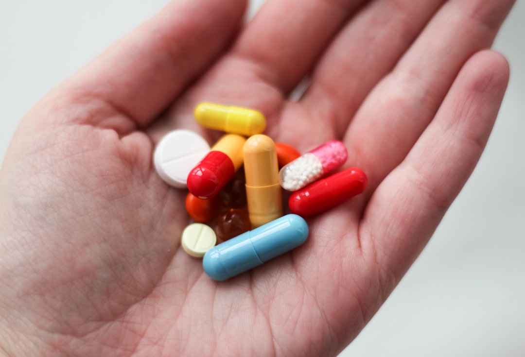 Photo by Ksenia Yakovleva orange and white medication pill on persons hand