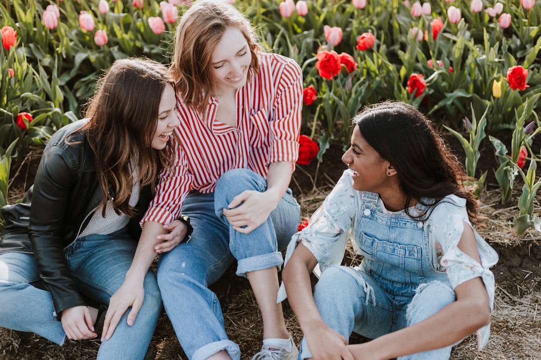 Photo by Priscilla Du Preez 🇨🇦 three woman sitting near the flower